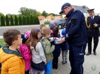 policjant częstuje dzieci cukierkami