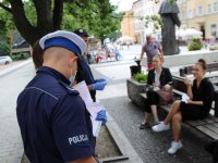 Policjanci rozdają ulotki z informacjami o służbie w Policji